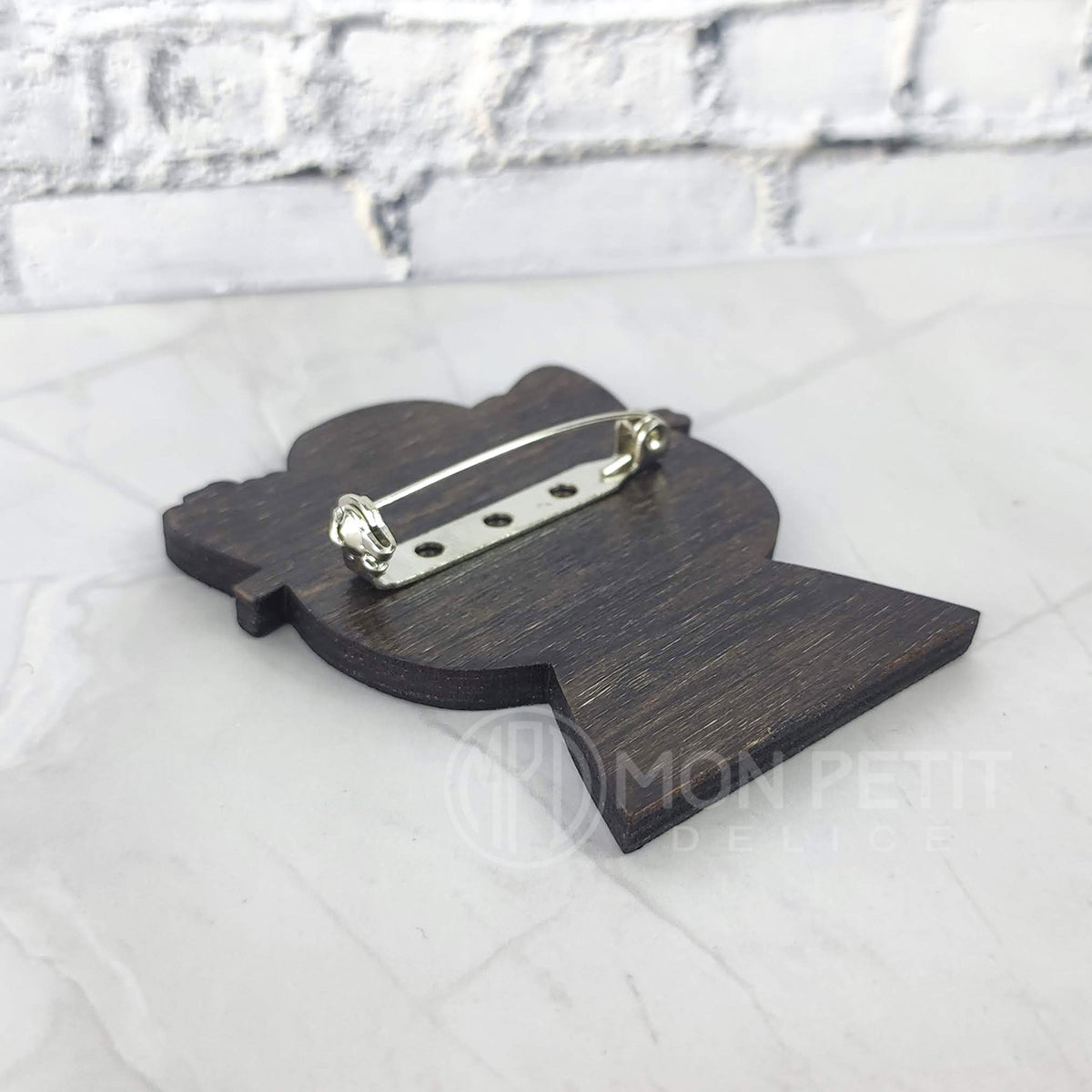 Back of handmade geisha cat wooden pin, showing the secure backing.