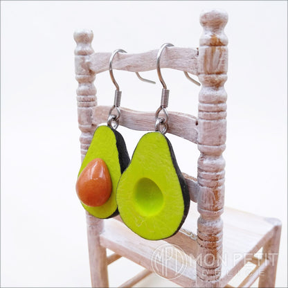 Side view of polymer clay avocado dangle earrings showing thickness and handmade finish.