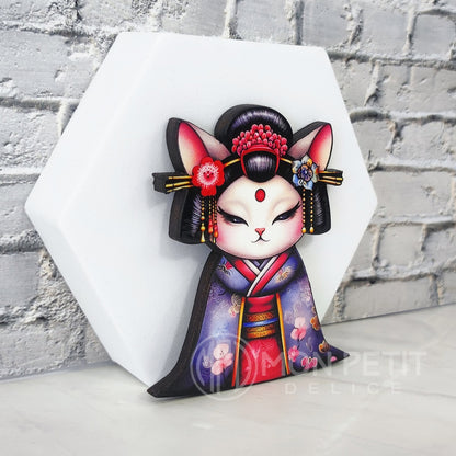 Close-up of Japanese style geisha cat pin, glossy wood finish.