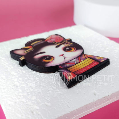 Close-up of elegant geisha cat illustration on a glossy wood pin.