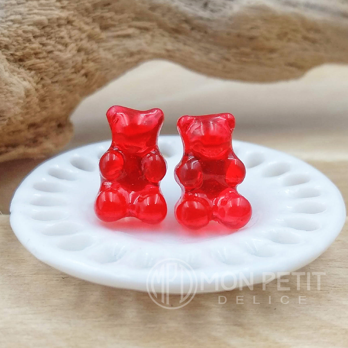Glossy miniature red gummy bear stud earrings in resin, kawaii candy jewelry front view.