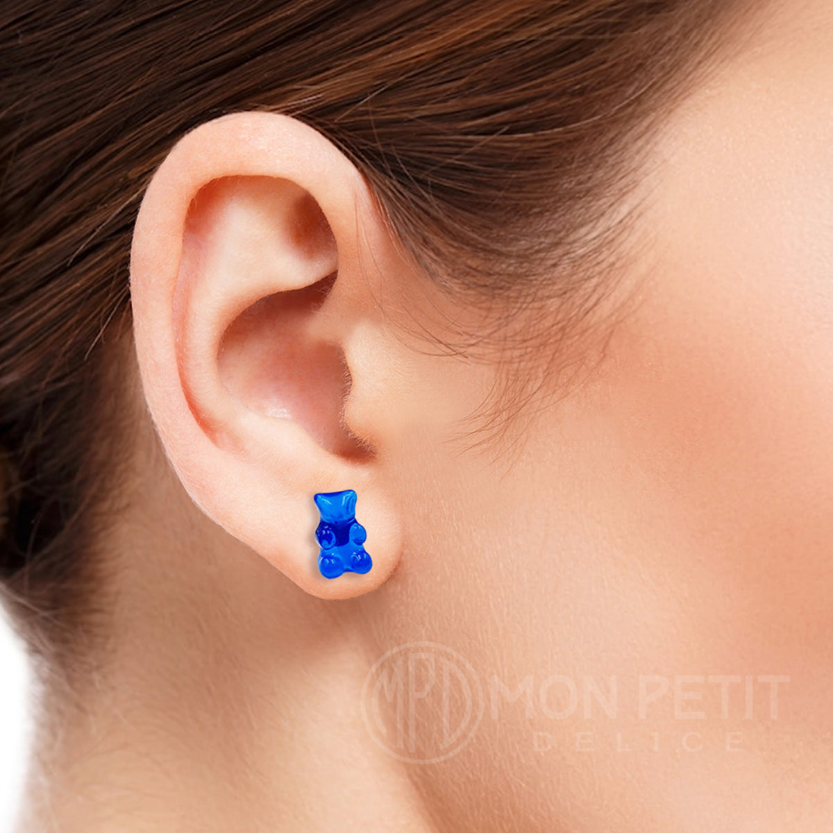 Blue gummy bear stud earring worn on the ear