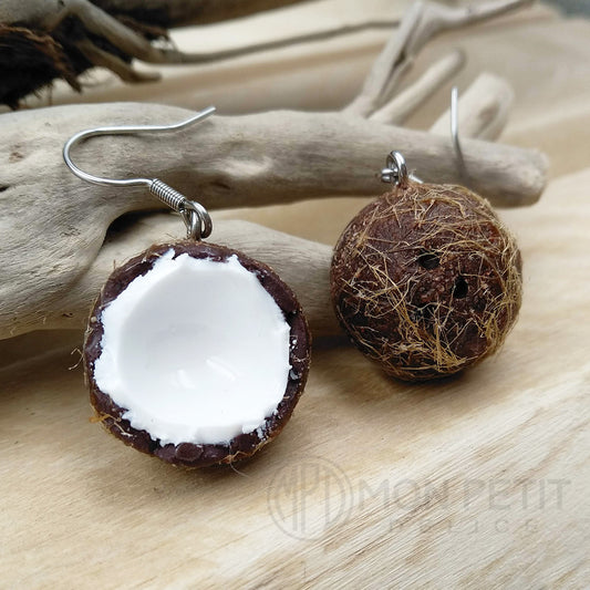 Close-up of handmade coconut dangle earrings with glossy finish