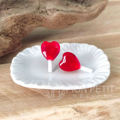 Red heart lollipop stud earrings handmade in resin, close-up view